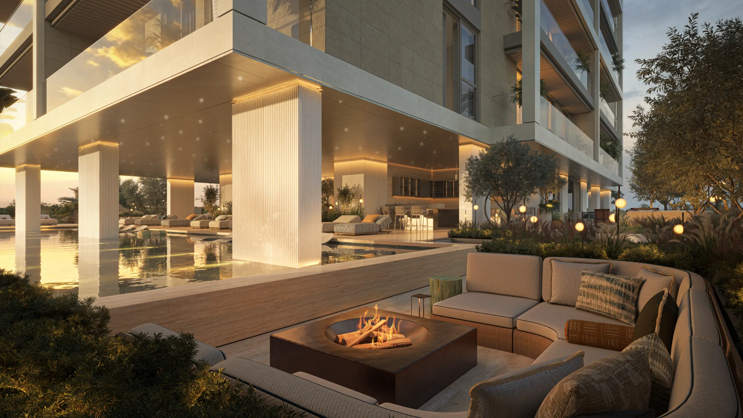 Sunken fire-pit lounge beside the pool at sunset